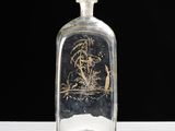 an old glass bottle with a picture of a man on a boat in a body of water