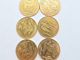 six different types of gold coins on a white surface