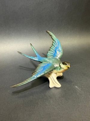a blue and green bird figurine sitting on a table