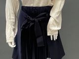 an image of a mannequin wearing a white blouse and black skirt