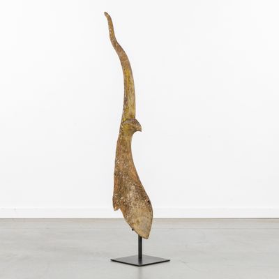 a sculpture of a bird on a metal stand in a white room