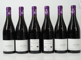 six bottles of wine are lined up on a table
