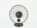 a black and white clock on a stand on a white background
