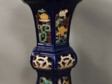un vase bleu orné d'un motif, posé sur une table