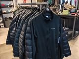 clothing on display in a clothing store with a rack full of jackets