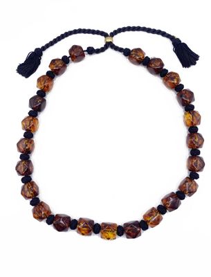 un collier composé de perles marron et noires, orné d'un pompon
