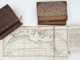 a map, a book, and a leather case sitting on a table