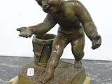 bronze statue of a boy with a bucket on a marble base