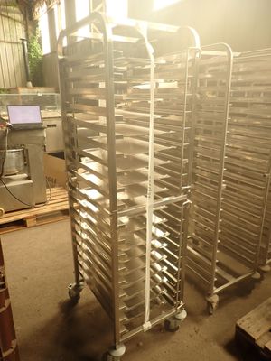 many trays of food on a metal rack in a warehouse