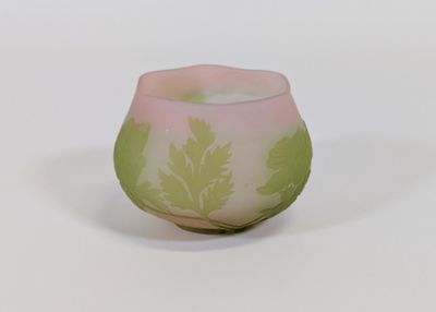 un vase en verre rose et vert orné de feuilles