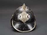 an old fireman ' s helmet with a gold emblem on it