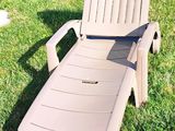 une chaise de jardin posée dans l'herbe