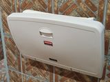 a picture of a bathroom with a toilet and a paper dispenser on the wall