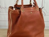 a brown handbag sitting on top of a wooden floor