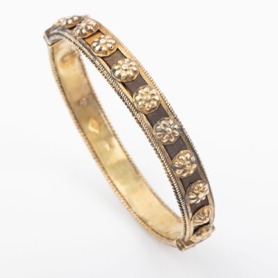 a close up of a gold and black enamel bangle