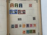 an open book with stamps on it on a table
