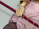 a doll that is sitting on the floor with a cane