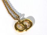 un collier en or sur lequel est gravée la lettre « g »