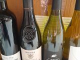 several bottles of wine are lined up on a wooden table