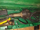 une boîte verte contenant des outils, posée sur un plancher en bois