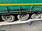a green semi truck that is parked on the side of the road