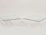 a pair of glass coffee tables with a geometric design