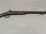 un vieux pistolet avec un canon et une crosse en bois