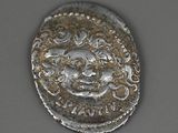 a close up of a silver coin with a face on it