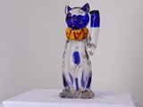 une figurine de chat en verre posée sur une table blanche