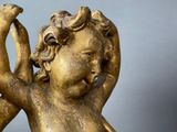 gold statue of a child holding a bird in his hands