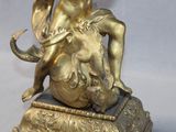 a gold statue of a woman sitting on top of an elephant