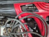 a red corded drill in a case with other tools
