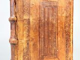 un vieux livre à la couverture en bois posé sur une table