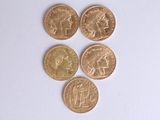four different types of gold coins on a white surface