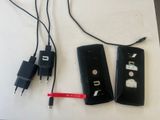 two remote controls and a charger on a table