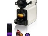 un gros plan d'une machine à café avec une tasse de café à côté