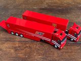 deux camions rouges posés sur une table en bois