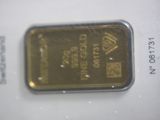 a gold bar sitting on top of a piece of paper