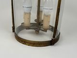 a glass lantern with two light bulbs inside of it