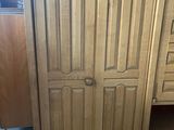 an image of a wooden cabinet with drawers and a door