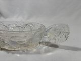 a glass bowl with a spoon on a white surface