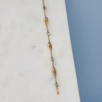 un gros plan d'un collier posé sur une surface en marbre