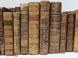 many old books lined up together on a white surface