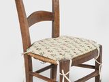 a wooden chair with a floral seat pad on it
