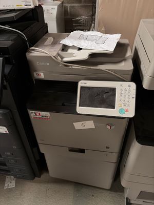 une pile d'imprimantes de bureau et une imprimante posée par terre