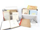 several books are sitting in a box on a white surface