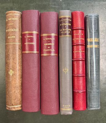 cinq vieux livres sont alignés les uns à côté des autres sur une étagère