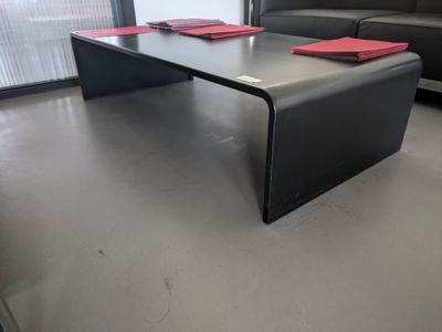 une table basse noire sur laquelle sont posées des serviettes rouges