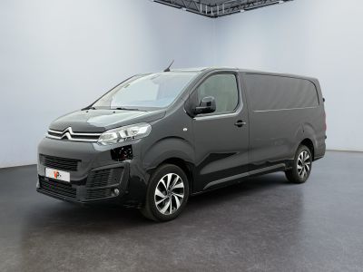 une camionnette grise garée dans une pièce blanche au sol noir