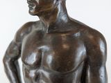 bronze statue of a man with a hat on his head and hands on his hips